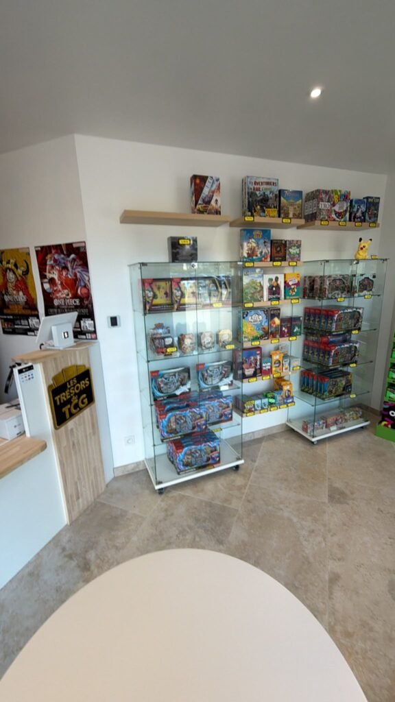 Vitrines de produits Pokémon et One Piece dans la boutique Les Trésors du TCG à Jacou